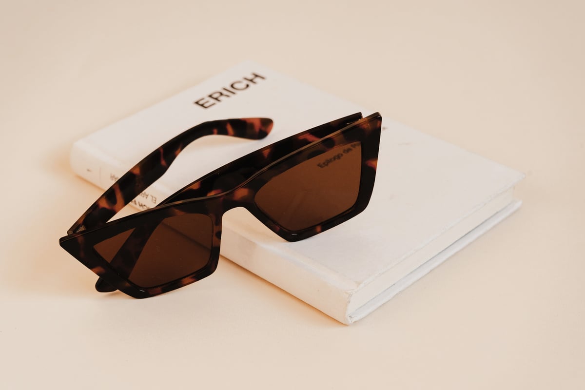 Brown Sunglasses with Book on Beige Background